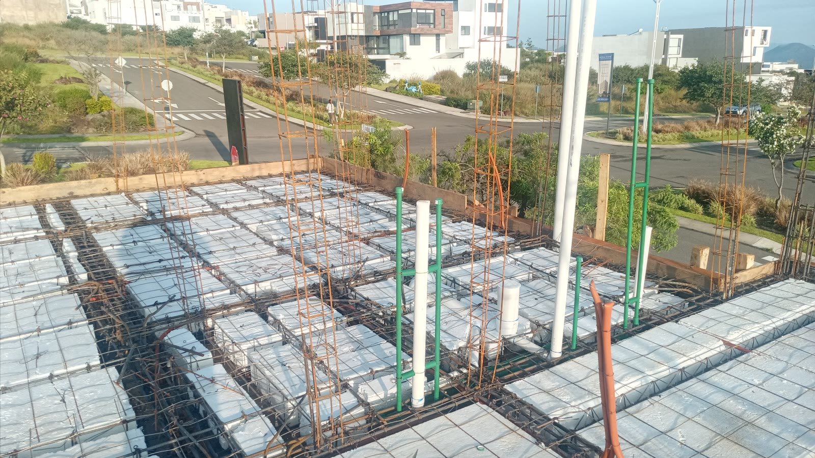 Losa aligerada con casetón y armado, atravesada por bajadas sanitarias de PVC, tubería hidráulica y poliducto eléctrico, con arranques de columna y vista al fraccionamiento.