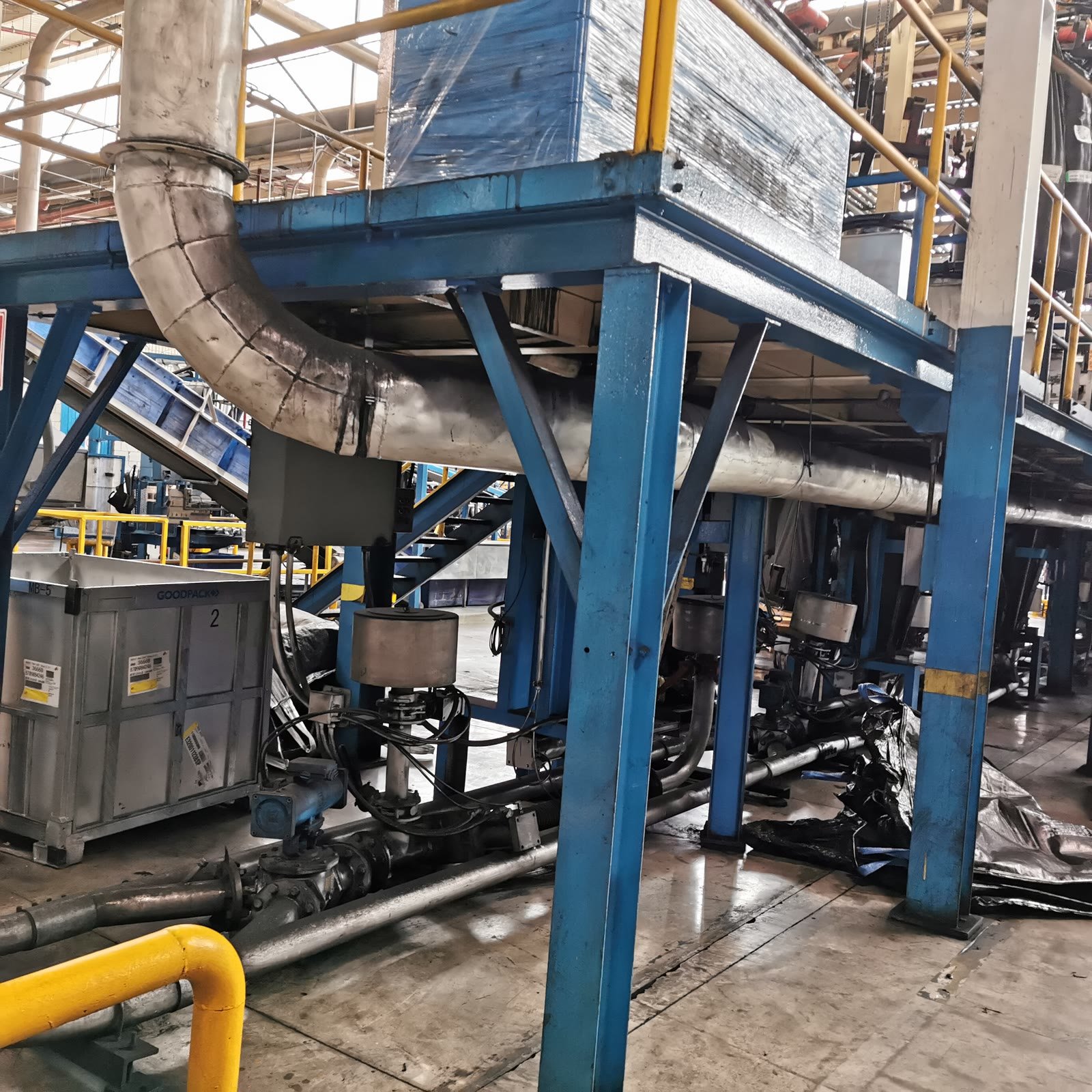 Plataforma estructural metálica con columnas, contravientos y tuberías de proceso en una planta industrial