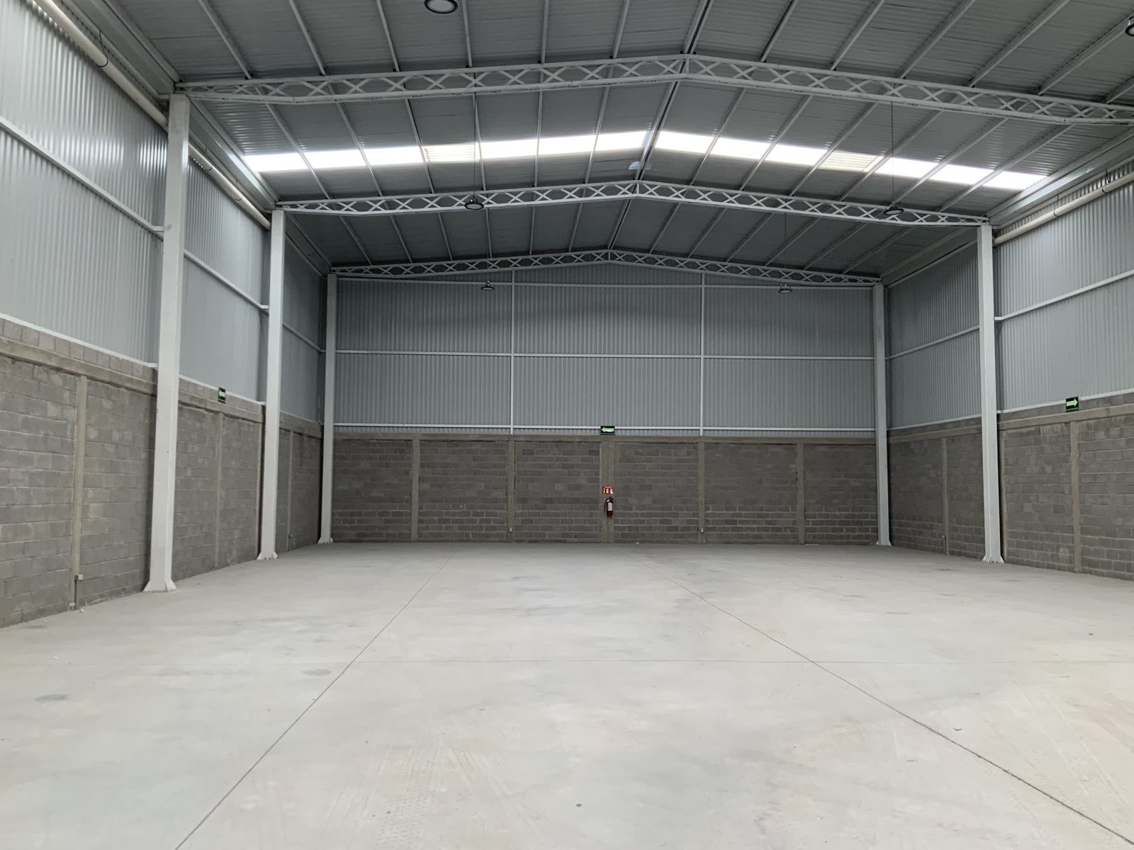 Nave industrial 47-C en Terra Park Centenario — interior terminado con armaduras de acero de la cubierta, muro de block y piso de concreto, El Marqués, Querétaro