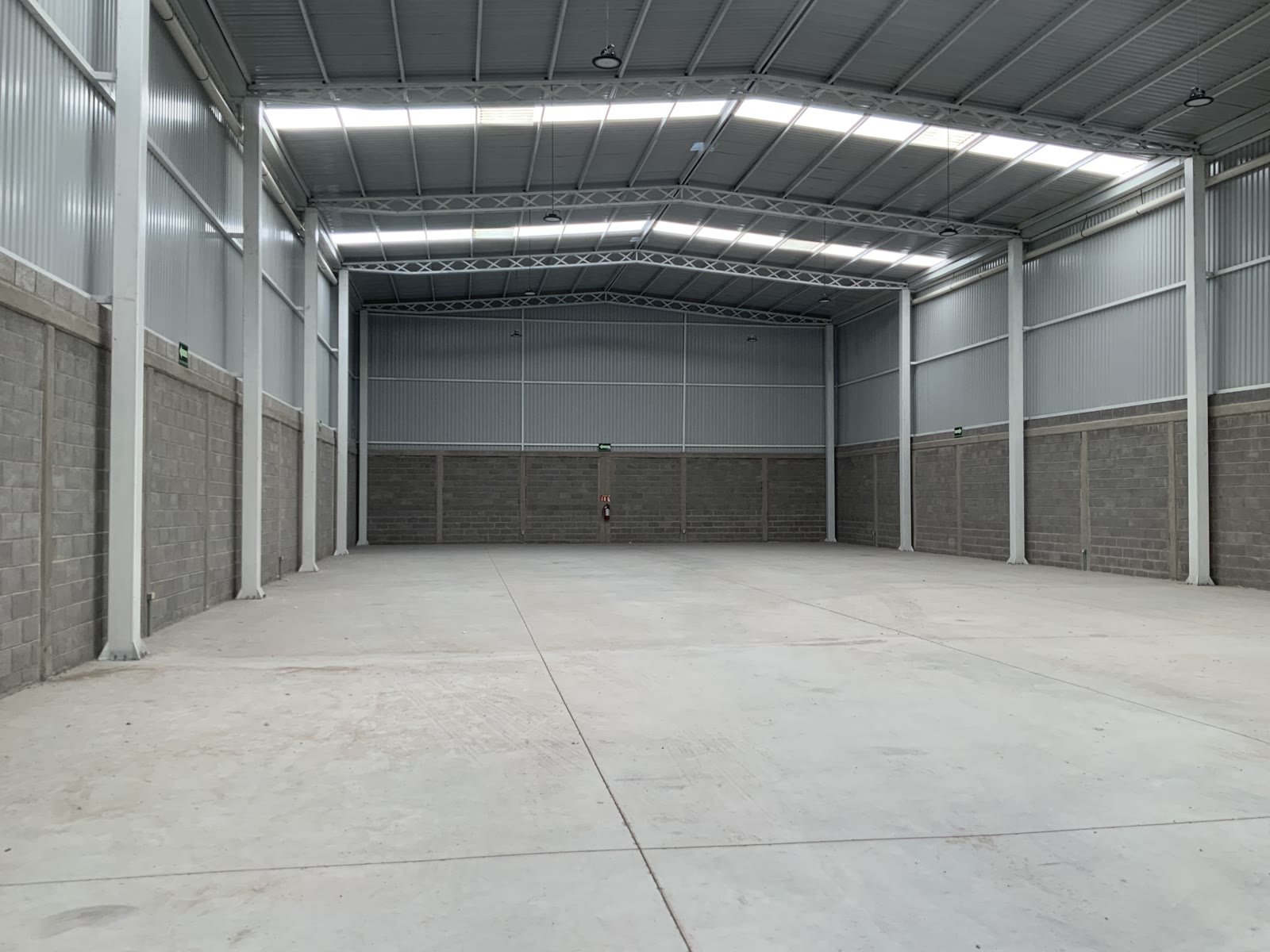 Nave industrial 47-C — vista completa del claro interior con estructura de acero, muros de panel y lucernarios, Terra Park Centenario, Querétaro