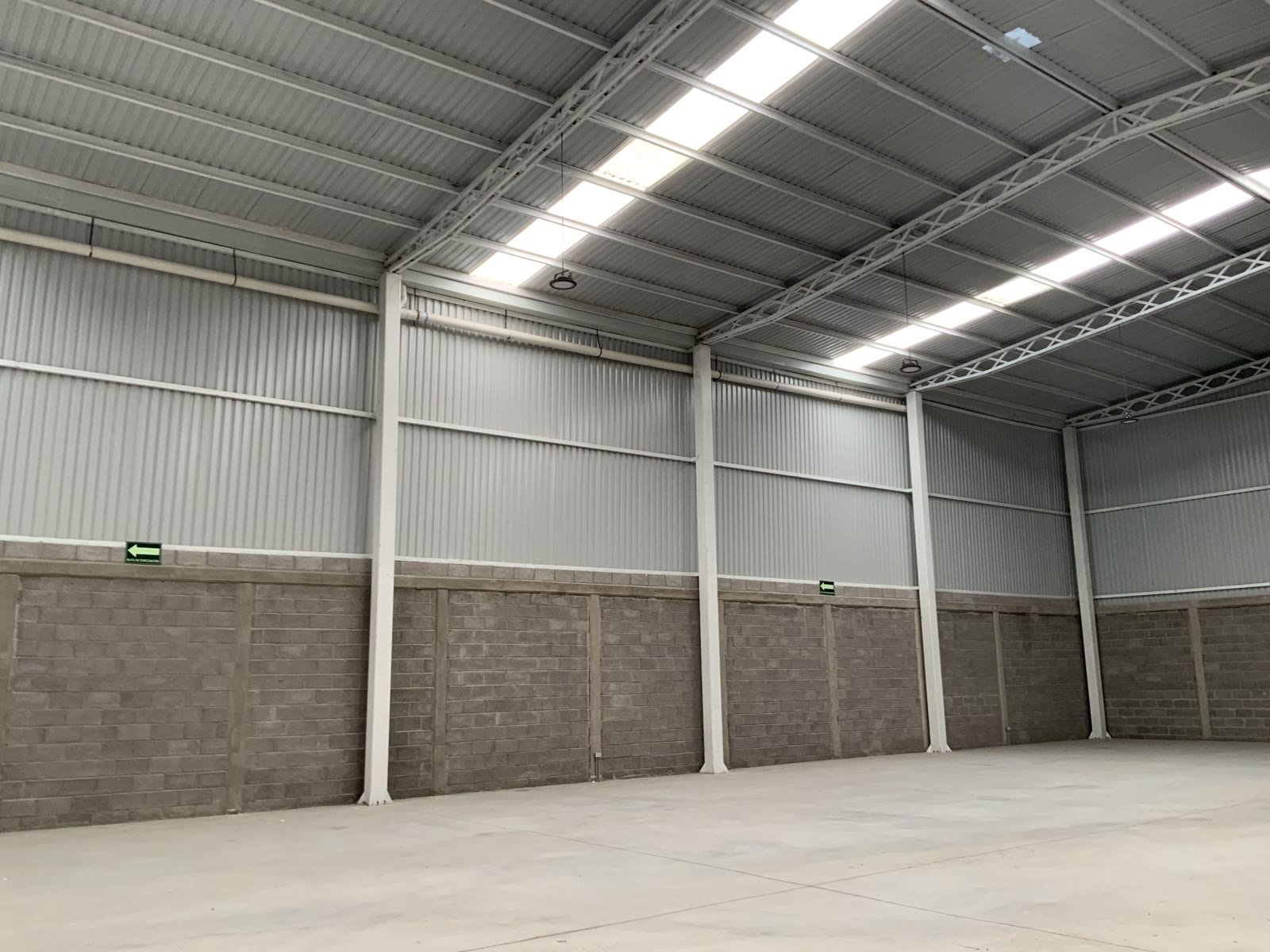 Nave industrial 47-C — perspectiva interior de la línea de columnas y la estructura de cubierta, Querétaro